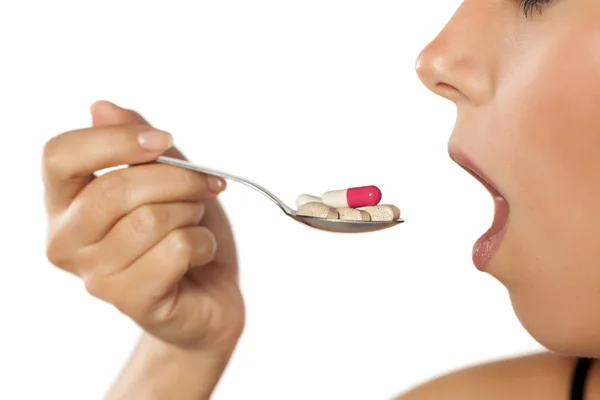 Woman eating drugs — Stock Photo, Image