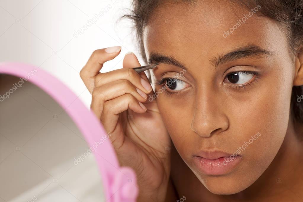 woman plucking her eyebrows