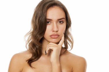 Dalgın genç güzel kadın beyaz bir arka plan üzerinde poz