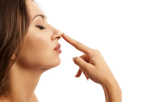 Kobieta dotyka nos — Zdjęcie stockowe