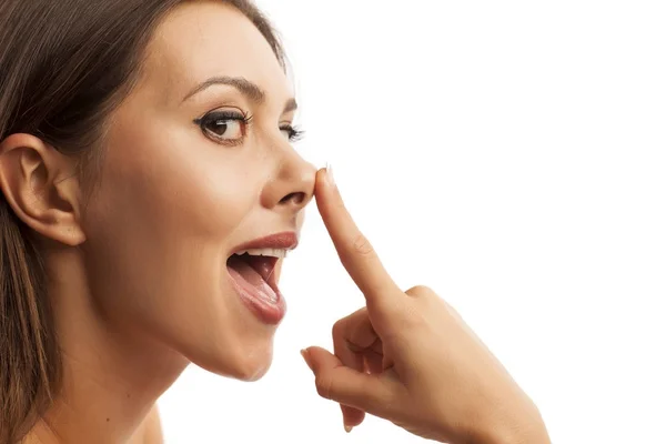 Kobieta dotyka nos — Zdjęcie stockowe