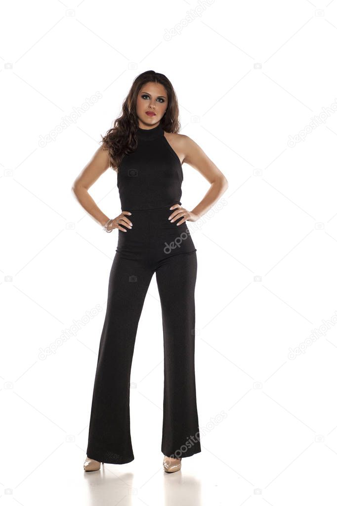 Woman in black sleeveless jumpsuit posing on a white background
