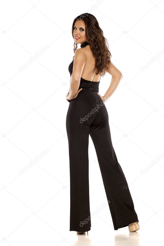 Back view of a happy woman in black backless and sleeveless jumpsuit