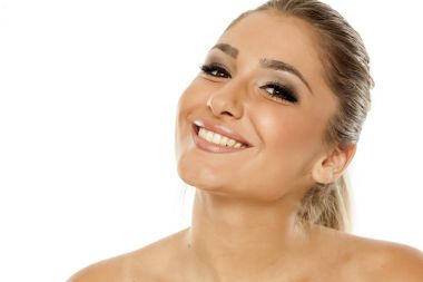 Güzel genç gülümseyen kadın beyaz bir arka plan üzerinde makyaj ile