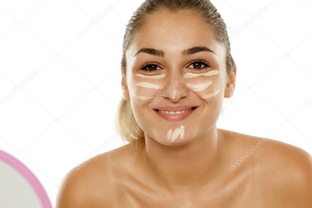 Young woman with corrective concealer on her face
