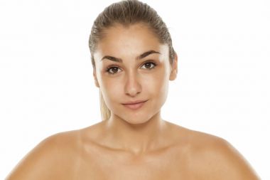 Beyaz bir arka plan üzerinde makyaj olmadan genç güzel kadın