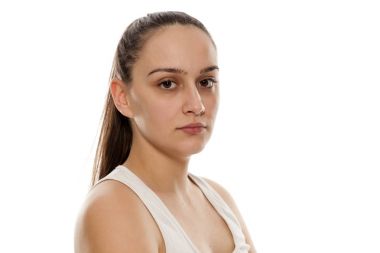 Beyaz bir arka plan üzerinde makyaj olmadan poz güzel genç kadın