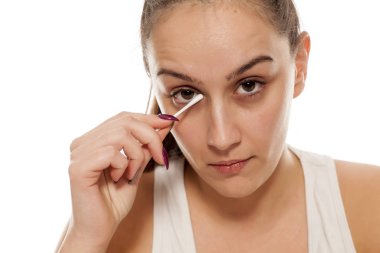 Genç kadın gözü ile bir pamuklu çubukla Temizleme