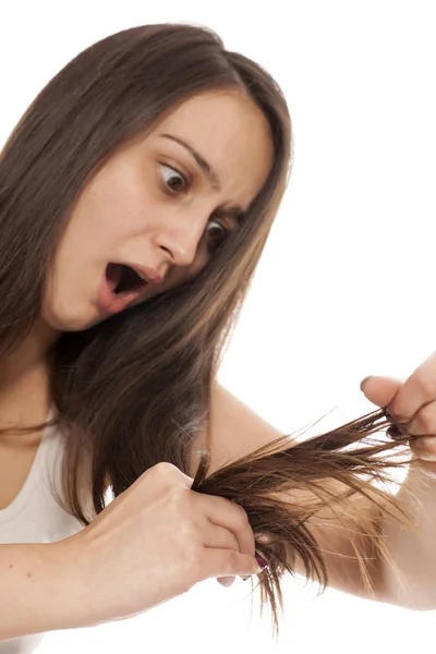 Junge Schockierte Frau Blickt Auf Die Gespaltenen Enden Ihrer Haare — Stockfoto