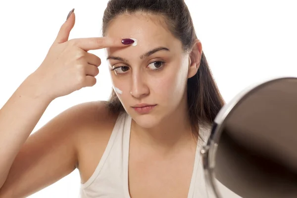 Jovem Bela Mulher Aplicando Creme Facial Seu Rosto — Fotografia de Stock