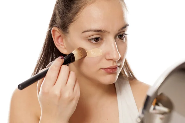Mujer Joven Que Aplica Una Base Líquida Cara Con Cepillo —  Fotos de Stock