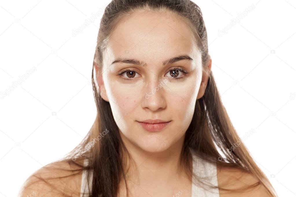 Young woman posing with a concealer under her eyes