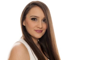 Beyaz bir arka plan üzerinde poz uzun düz saçlı genç güzel kadın