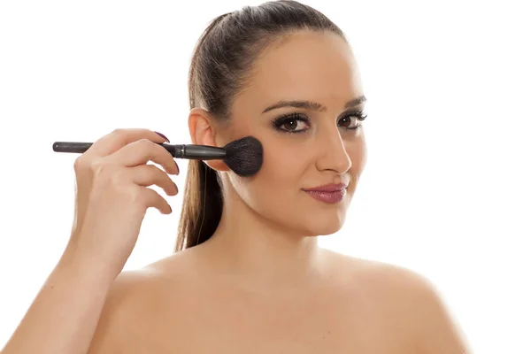 Mujer Joven Aplicando Rubor Cara Con Cepillo —  Fotos de Stock