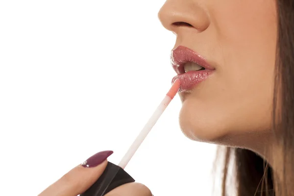 Junge Frau Trägt Lipgloss Auf Weißem Hintergrund Auf — Stockfoto