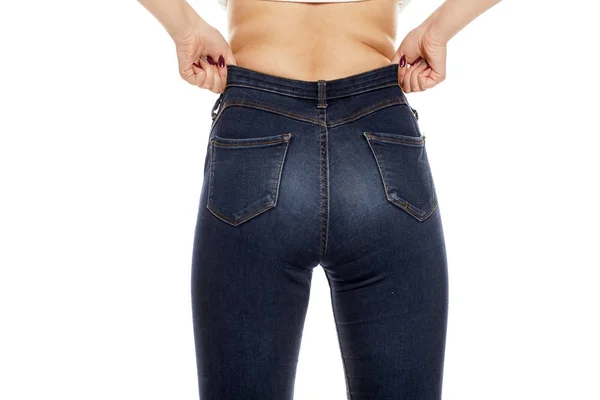 若い女性が彼女のジーンズをドレッシングの背面図 — ストック写真