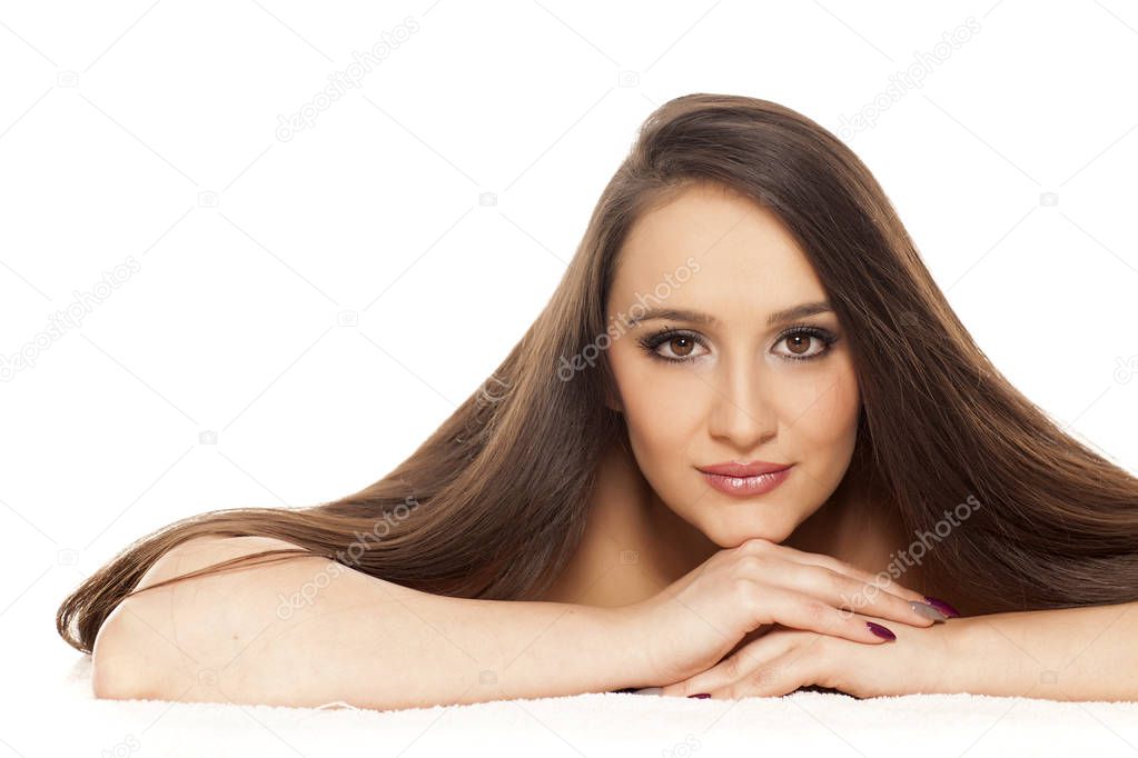 Young woman with long straight hair posing on a white background