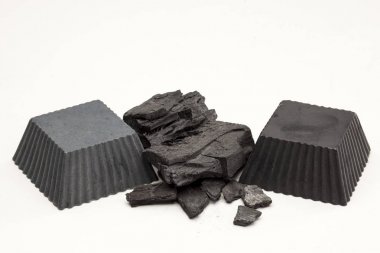 İki el beyaz arka plan üzerinde siyah aktif kömür sabun yapımı