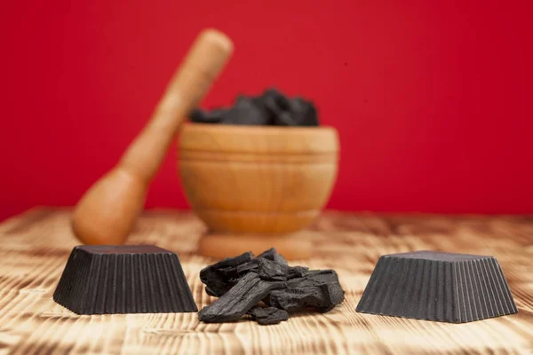 Hand made black activated charcoal soap on red background