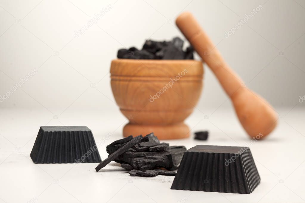 Two hand made black activated charcoal soaps on white background