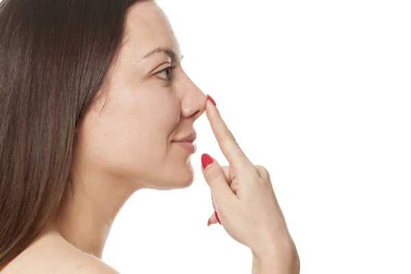 白い背景の上の彼女の鼻に触れる女性 — ストック写真