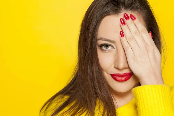 Hermosa Mujer Blusa Amarilla Cubriéndose Ojo Con Mano Sobre Fondo —  Fotos de Stock