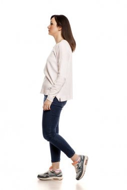 Beyaz bir arka plan üzerinde yürüyen genç bir kadın profili görünümü