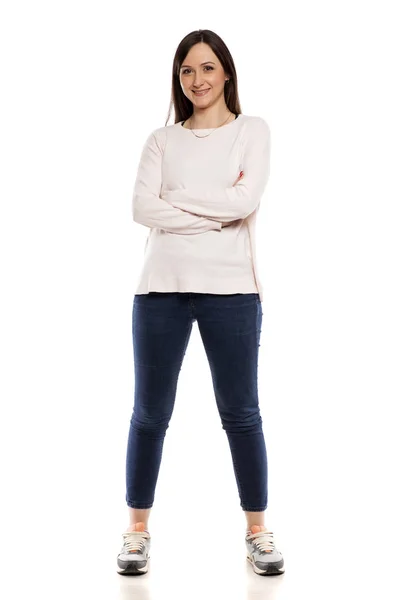 白色背景牛仔裤 上衣和运动鞋的年轻妇女 — 图库照片
