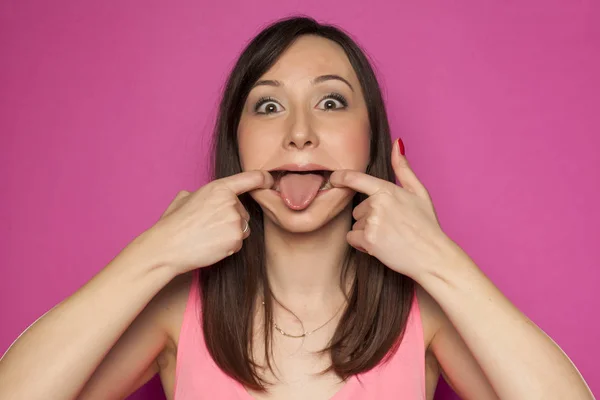 Engraçado Jovem Mulher Fazendo Caras Bobas Fundo Rosa — Fotografia de Stock