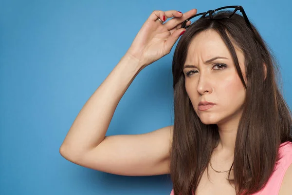 Young Woman Looking Suspiciously Blue Background — Stock Photo, Image