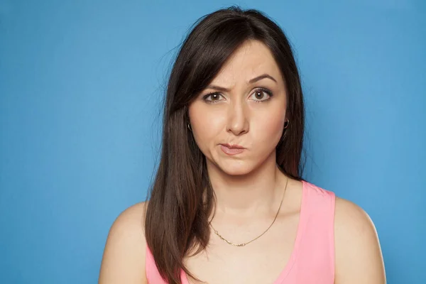 Young Woman Looking Suspiciously Blue Background — Stock Photo, Image