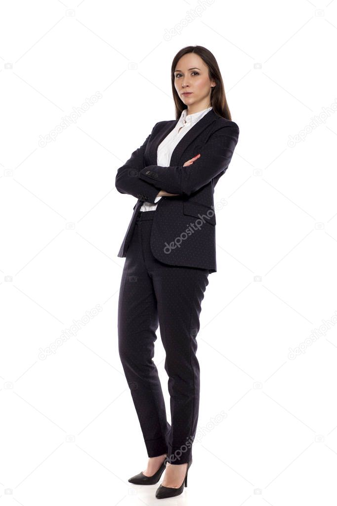 Serious businesswoman standing on a white background with folded arms