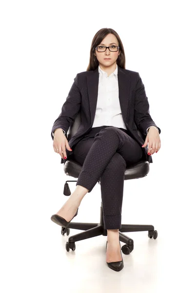 严肃的女商人在办公室椅子上摆出白色背景 — 图库照片