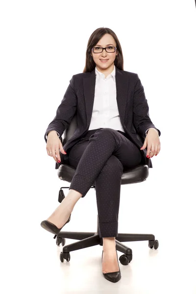 白い背景にポーズのオフィスの椅子の笑みを浮かべて女性実業家 — ストック写真