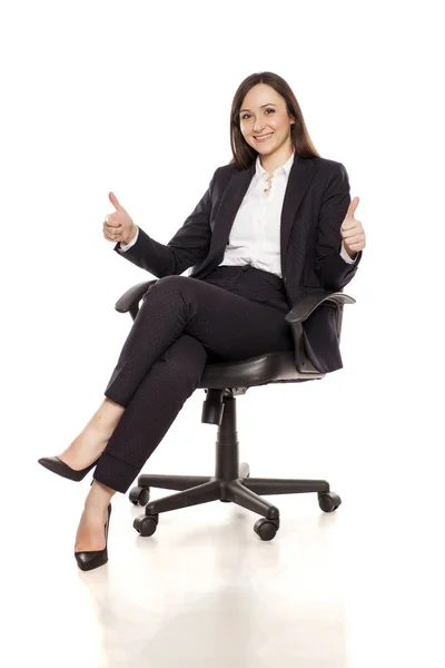 Mujer Negocios Sonriente Una Silla Oficina Mostrando Los Pulgares Hacia —  Fotos de Stock