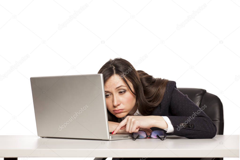 Young tired business woman working at a desk with a laptop