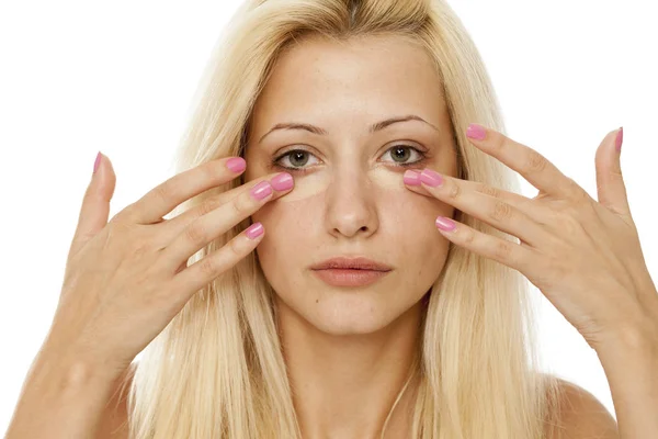 Mujer Rubia Joven Aplicando Corrector Bajo Sus Ojos — Foto de Stock