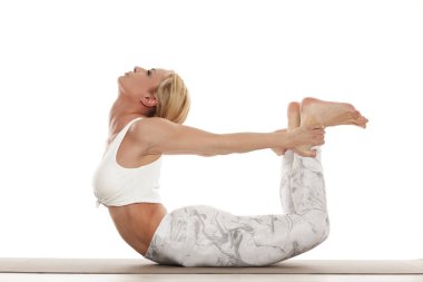 Yoga, spor, eğitim ve yaşam tarzı kavramı - yoga egzersiz yaparak sarışın genç kadın. Beyaz spor giyim yoga pratik yapıyor bir genç güzel kadın portresi.