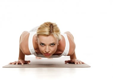 Yoga, spor, eğitim ve yaşam tarzı kavramı - yoga egzersiz yaparak sarışın genç kadın. Şınav beyaz spor giyim bir genç güzel kadın portresi.
