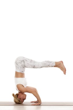 Sehpa masası. Mukta Hasta Sirsasana. Yoga, spor, eğitim ve yaşam tarzı kavramı - beyaz spor giyim yoga egzersiz yaparak genç sarışın kadın.