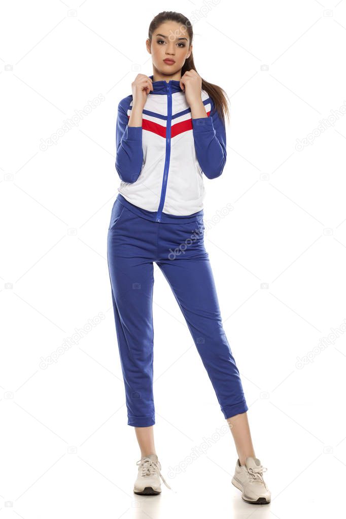 Young beautiful woman in blue tracksuits on a white background