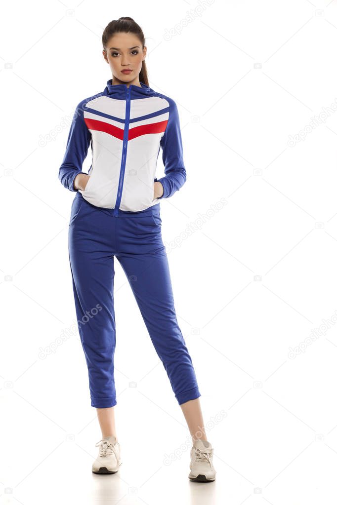Young beautiful woman in blue tracksuits on a white background