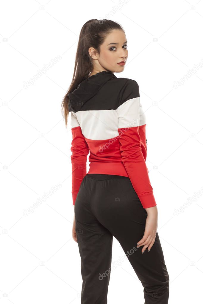 Young beautiful woman in black and red tracksuits on a white background