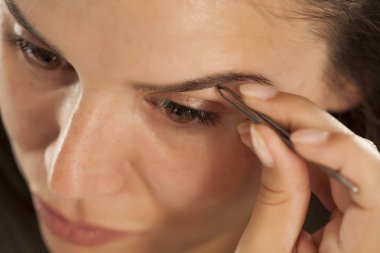 Kaşlarını cımbızla koparma genç güzel kadın