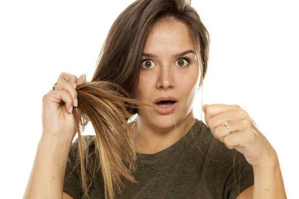 Scioccato Giovane Donna Mostrando Suoi Capelli Perdita Uno Sfondo Bianco — Foto Stock