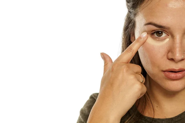 Young Woman Applying Concealer Her Eyes White Background — Stock Photo, Image