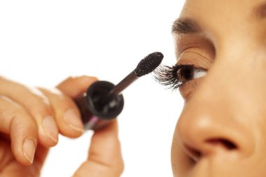 Kadının kirpiklerine rimel sürerken yakın plan fotoğrafı.