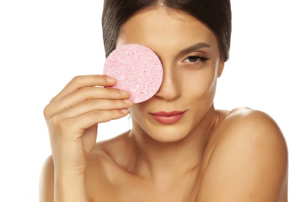 Young beautiful woman posing with a sponge pad on the white back — Stock Photo, Image