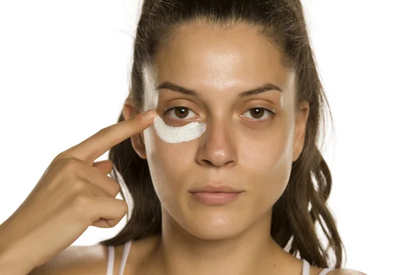 Young Woman Applying Face Cream Heer Eyes White Background — Stock Photo, Image
