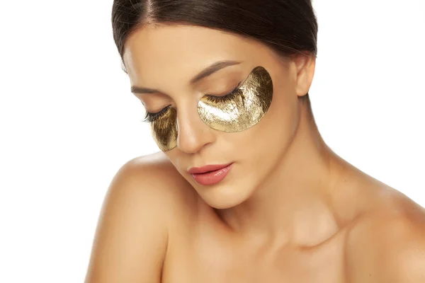 Wanita cantik muda berpose dengan patch emas di bawah matanya — Stok Foto